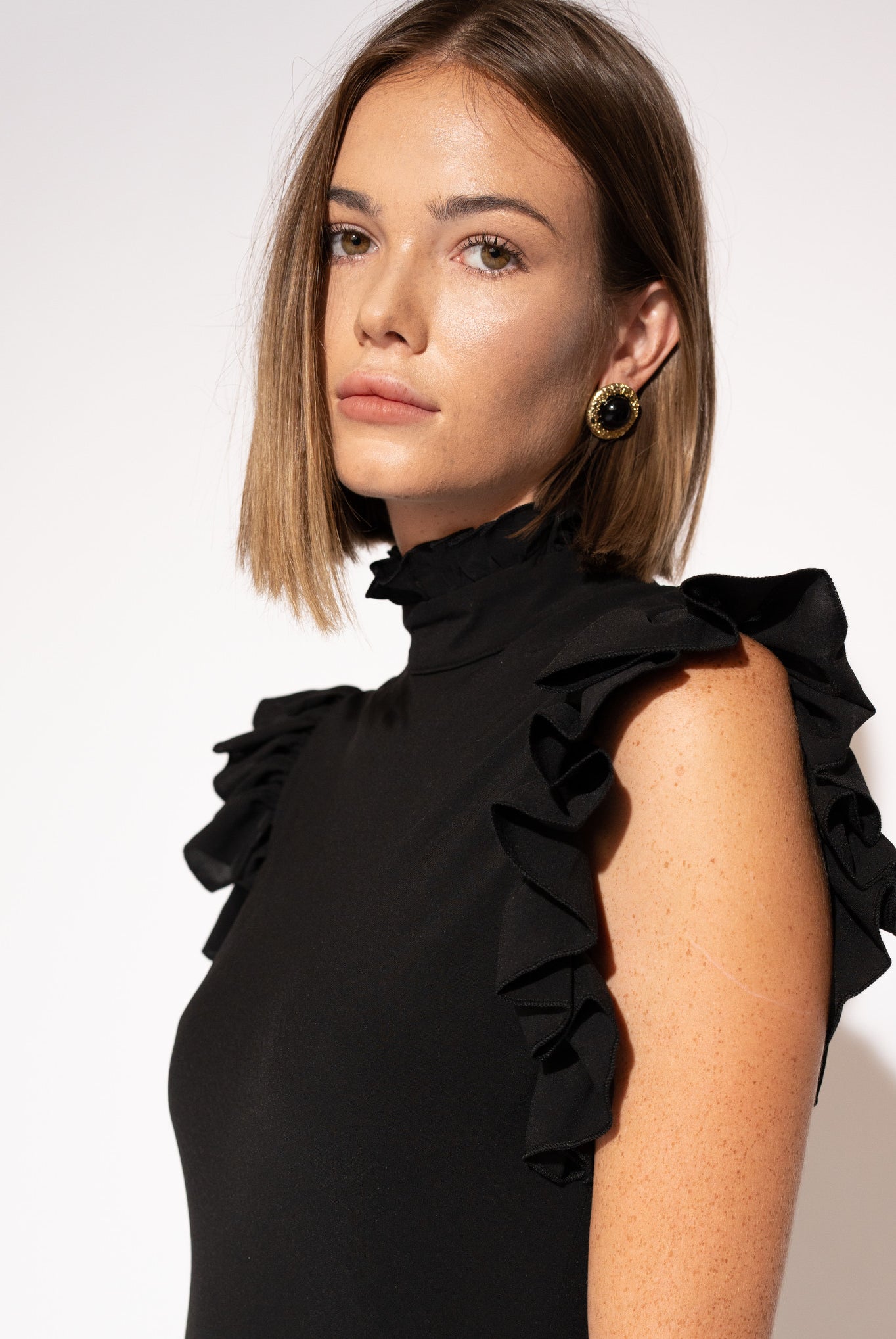 Close-up of model wearing High-Neck Ruffle Sleeve Maxi Dress – Black.