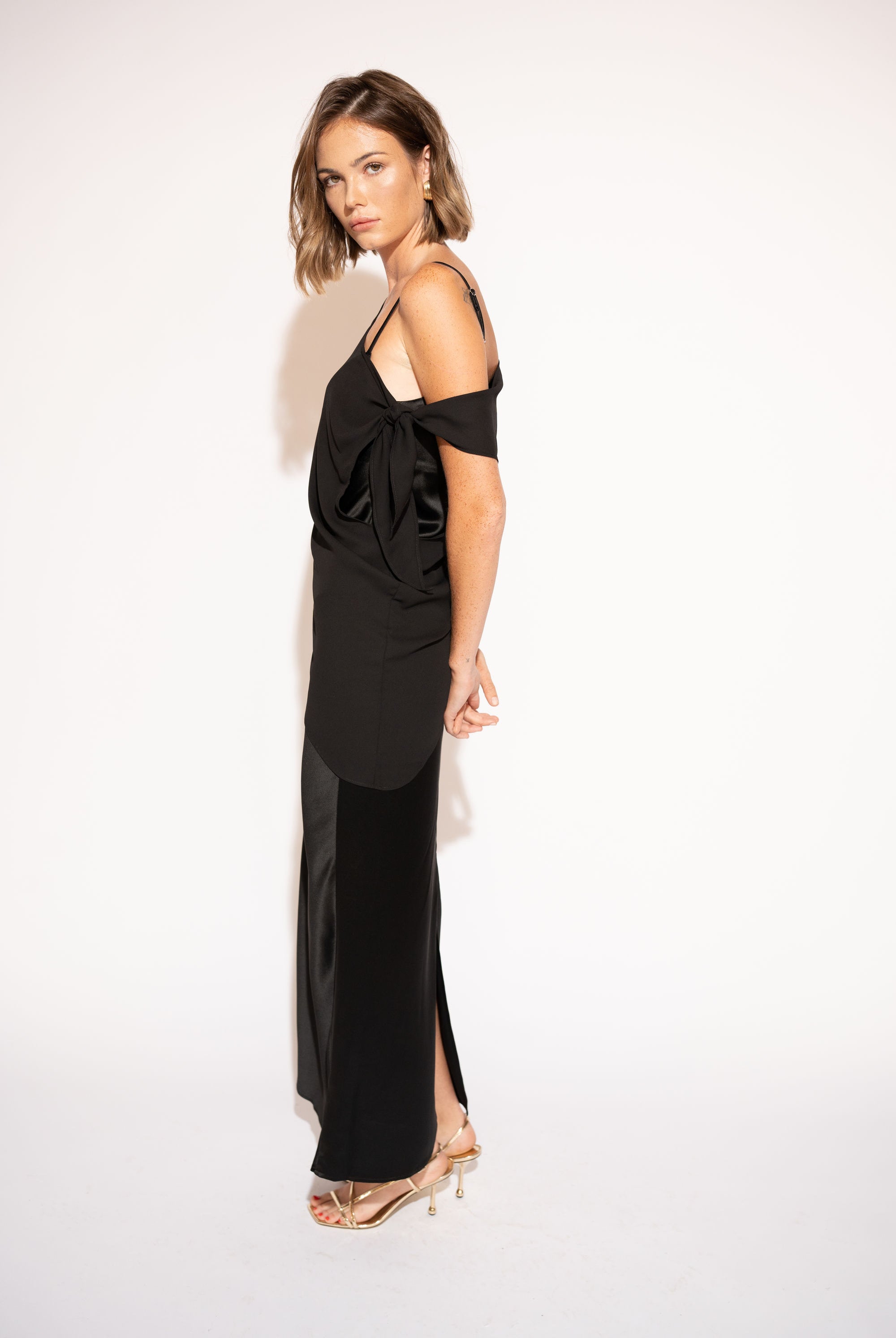 Side view with white background of Asymmetrical Mesh-Spliced Satin Maxi Dress – Black by Aisl.