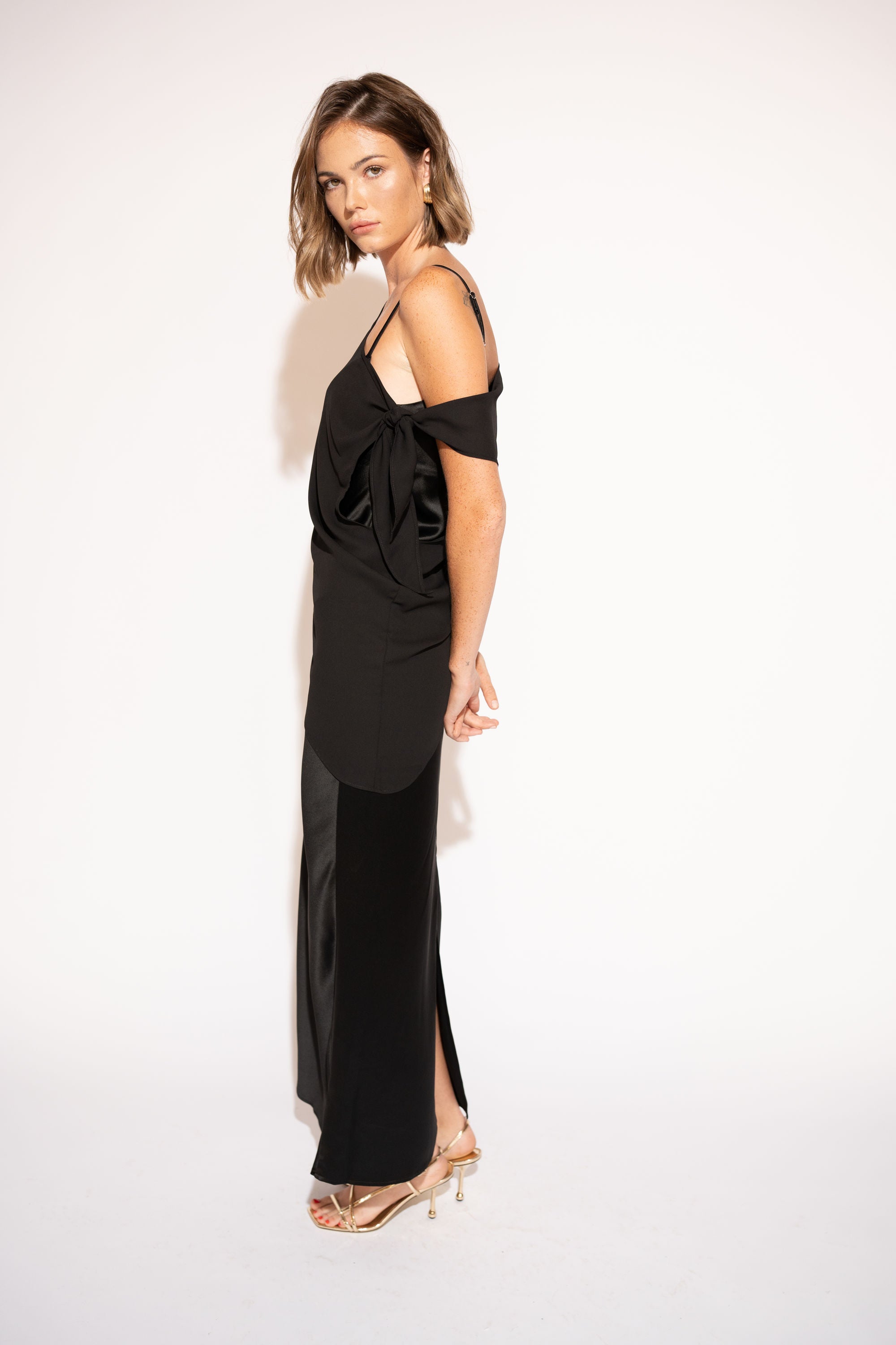 Side view with white background of Asymmetrical Mesh-Spliced Satin Maxi Dress – Black by Aisl.