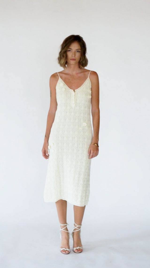 Video of model wearing Hand-Woven Cotton Midi Dress with Floral Detail – Ivory.