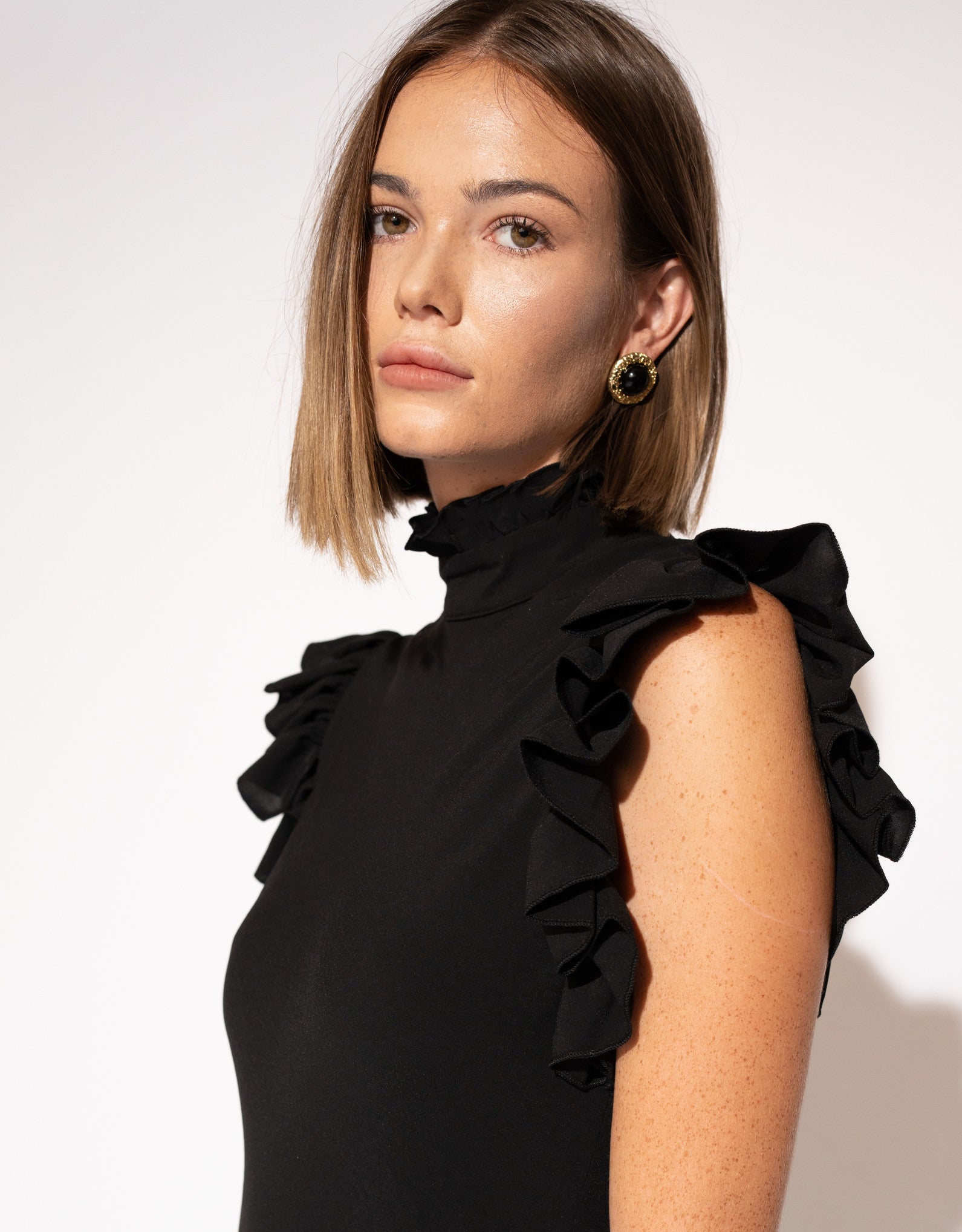 Close-up of model wearing High-Neck Ruffle Sleeve Maxi Dress – Black. 